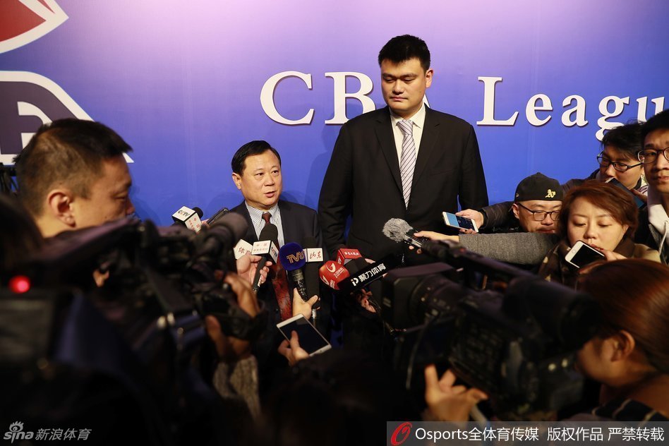 当董事长李金生（左）在交谈中侧身靠近时，姚明立刻配合地将头偏向一侧，专注地侧耳倾听，这一细微的动作展现了他对前辈的尊重以及在合作中虚心求教的态度。