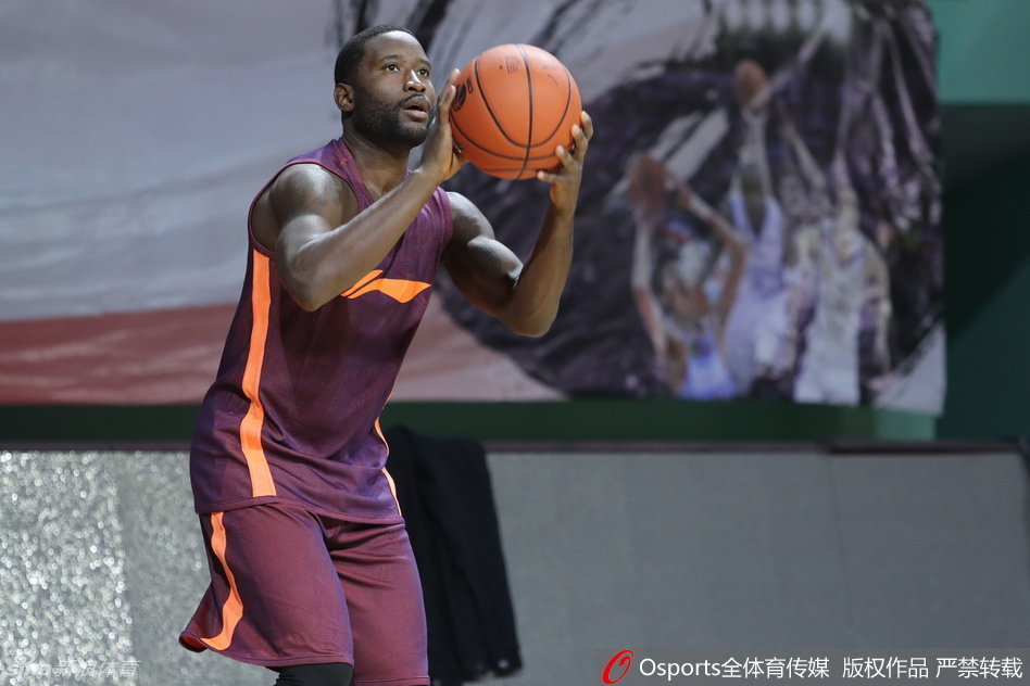 广东队组织核心斯隆在赛前训练中专注跳投，篮球划过球场上空的优美弧线。