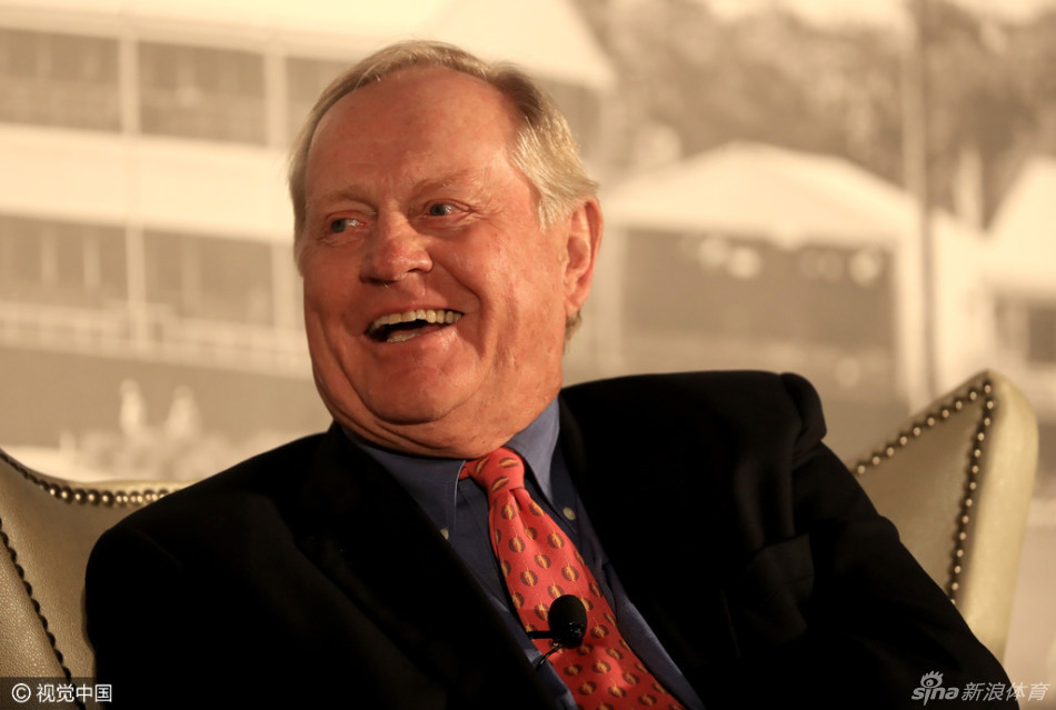 “金熊”尼克劳斯侧耳聆听提问，眼神专注而深邃，嘴角带着洞察世事的平和微笑。