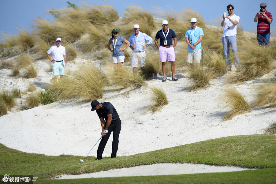 伍兹在球道上沉稳进行铁杆击球，身体重心完美左移，杆头扎实触球，草屑随势飞扬。