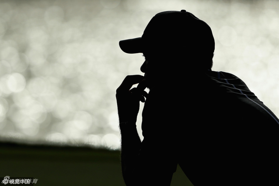 局间休息时，伍兹独自坐在一旁陷入深思，手中的毛巾和沉静的面容透露出比赛的艰辛与他的专注。