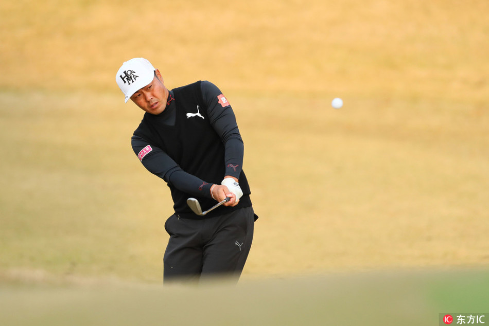 石川辽在果岭上屈膝专注察看推杆线路，神情严肃，胜负心尽显