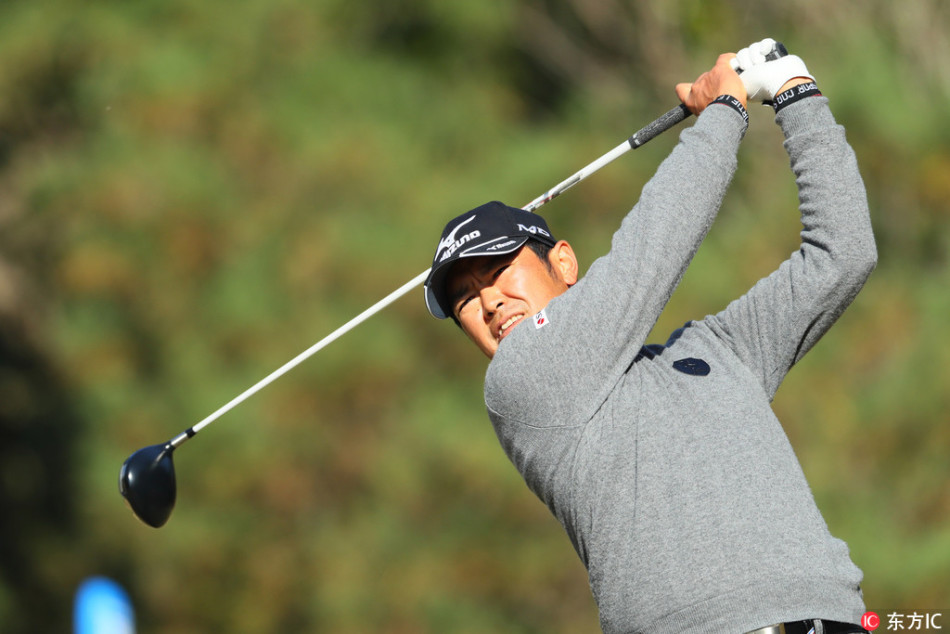 谷原秀人于球场树影下观察球路，眼神锐利，思索着下一杆的策略