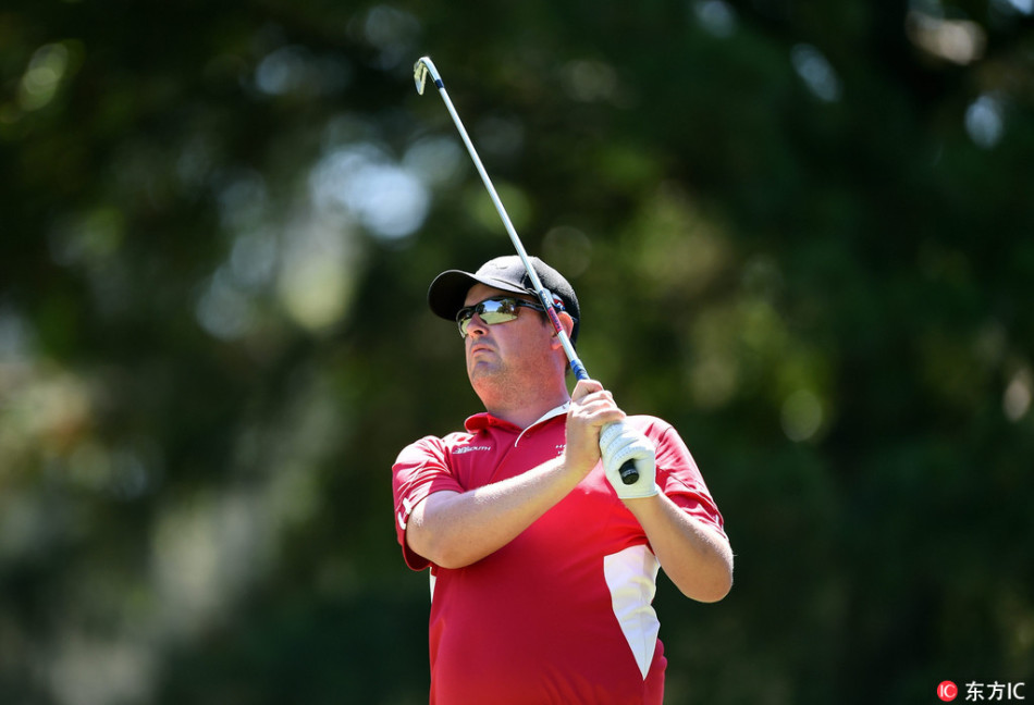 英格兰高尔夫球星伊恩·保尔特在长草中沉着应对,准备一记精巧的切球。