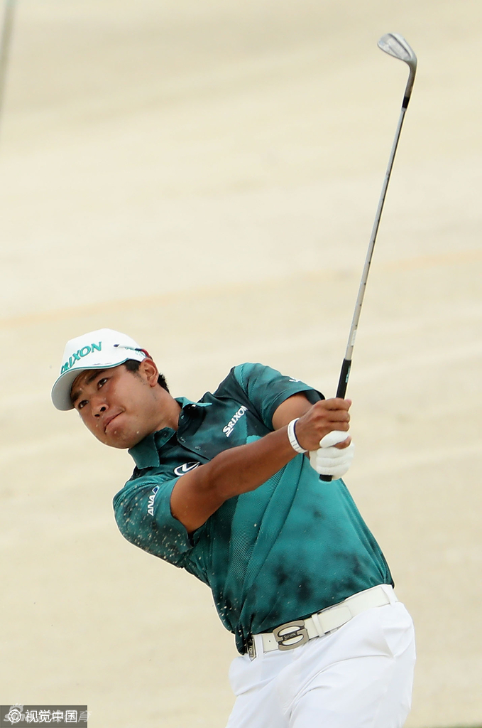 伍兹在全神贯注地完成一次关键推杆，身体姿态稳定如山，胜负尽在这沉稳一击之间