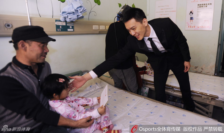 病房中杨鸣俯身与小朋友亲切交流，眼神温柔充满关爱，传递着无限暖意