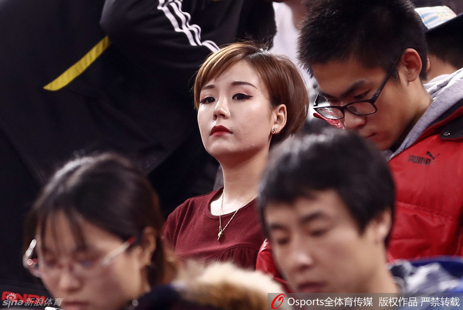 即便周围球迷情绪激动，她依然安静地坐在那里，手举充气棒轻轻靠在唇边，一双会说话的眼睛仿佛看穿了赛场的每一个战术变化。