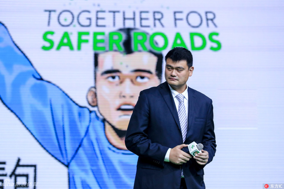 姚明身着西装，表情严肃地伸手点赞，倡导大家为文明出行的好司机点个赞