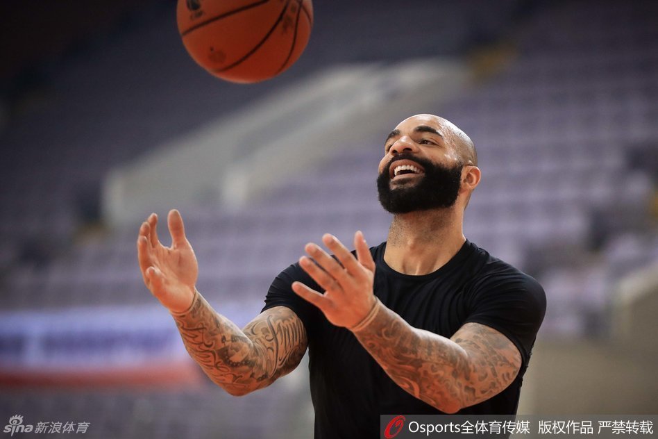 易建联在遭遇包夹时高高跃起，手腕轻抖，巧妙地将球传给篮下空位的队友，这一瞬间充分展现了他的核心策应能力。