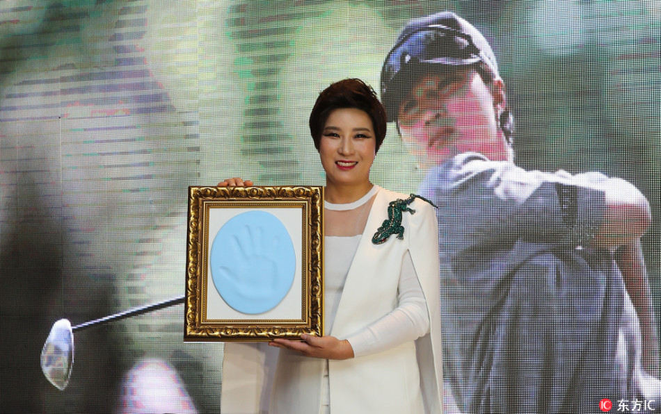 传奇球后朴世莉面带微笑，正郑重其事地在纪念泥板上按下自己的手印，瞬间定格为历史的一部分