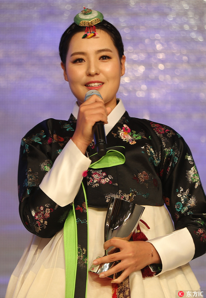 朴成炫作为颁奖嘉宾，正微笑着将一座晶莹剔透的奖杯颁出，眼神中充满对后辈的鼓励