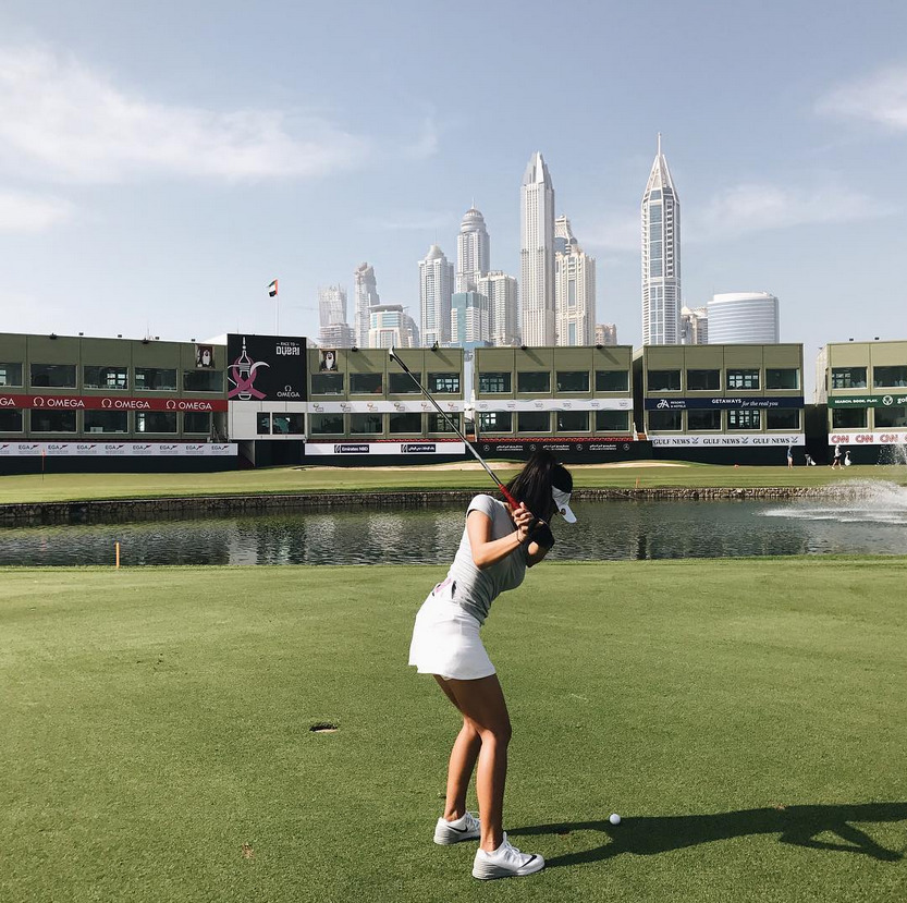 迪拜阳光下，白衣少女自信挥杆，球杆划破长空留下一道银色轨迹。