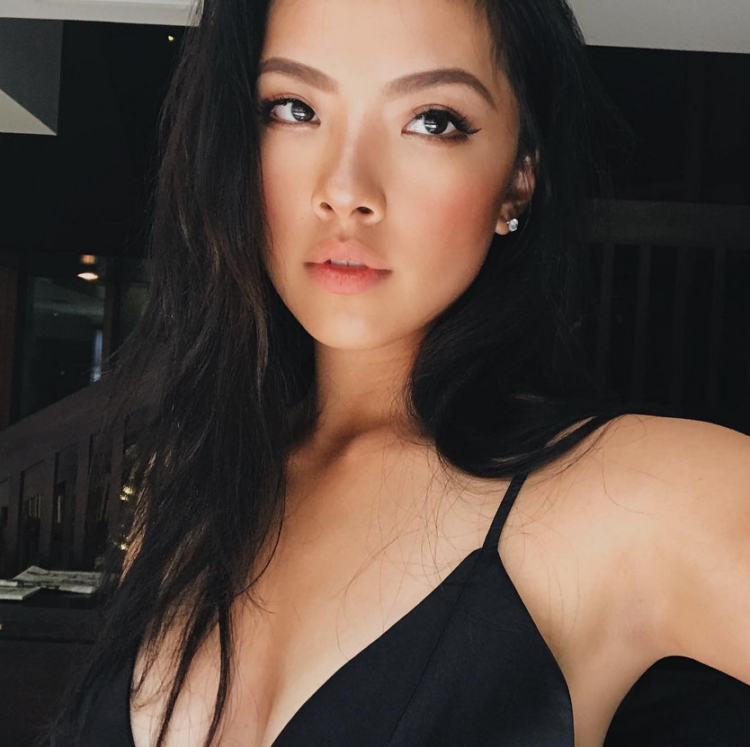 少女回眸一笑，甜美妆容与身后广阔的球场构成一幅充满活力的青春画卷。