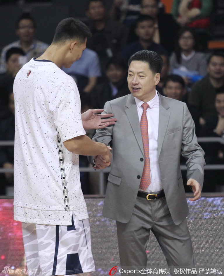 在漫天金色雨幕下，李春江教練與愛徒易建聯用力擁抱，兩人的笑容裡承載著共同奪得桂冠的喜悅與對彼此的絕對信任。