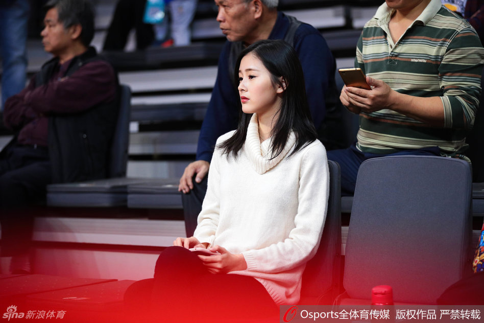 目光锁定赛场，这位白衣女球迷在广东队一次成功的防守后，露出了浅浅的梨涡，那份专注与美丽让人心动。