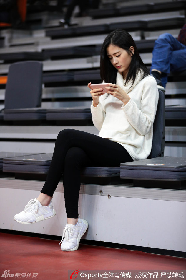 面对镜头的捕捉，这位女球迷莞尔一笑，随意披散的长发和若隐若现的锁骨，展现出东方女性特有的柔美与性感。