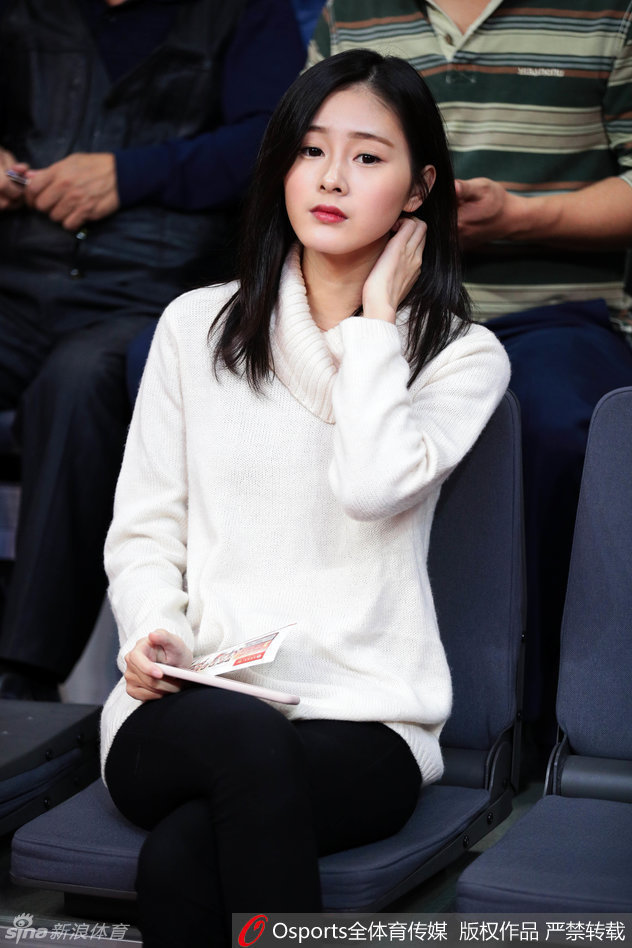 这位女球迷在广东队进攻得手后振臂欢呼，随性的白色T恤挡不住出众的气质，肤白貌美与热血篮球相得益彰。