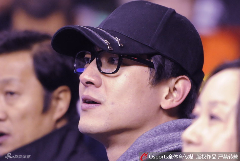 林更新现身辽宁主场，他面带温暖笑容，一袭黑色休闲便装显得格外清爽，正快步走向自己的座位，眼神中充满对比赛的期待。