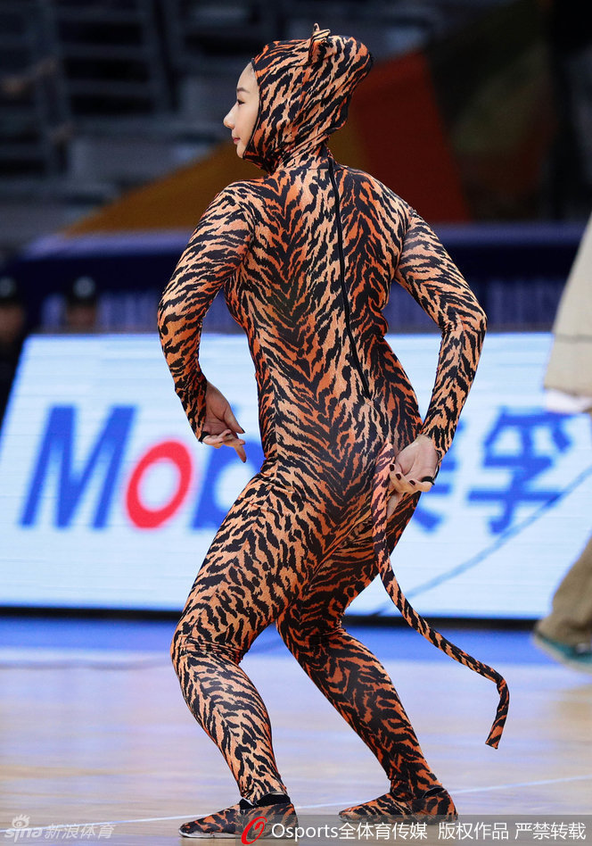 啦啦队员在比赛暂停间隙进行暖场表演，动作整齐划一，充满力量感，背景是巨大的CBA联赛标志和热情的观众。