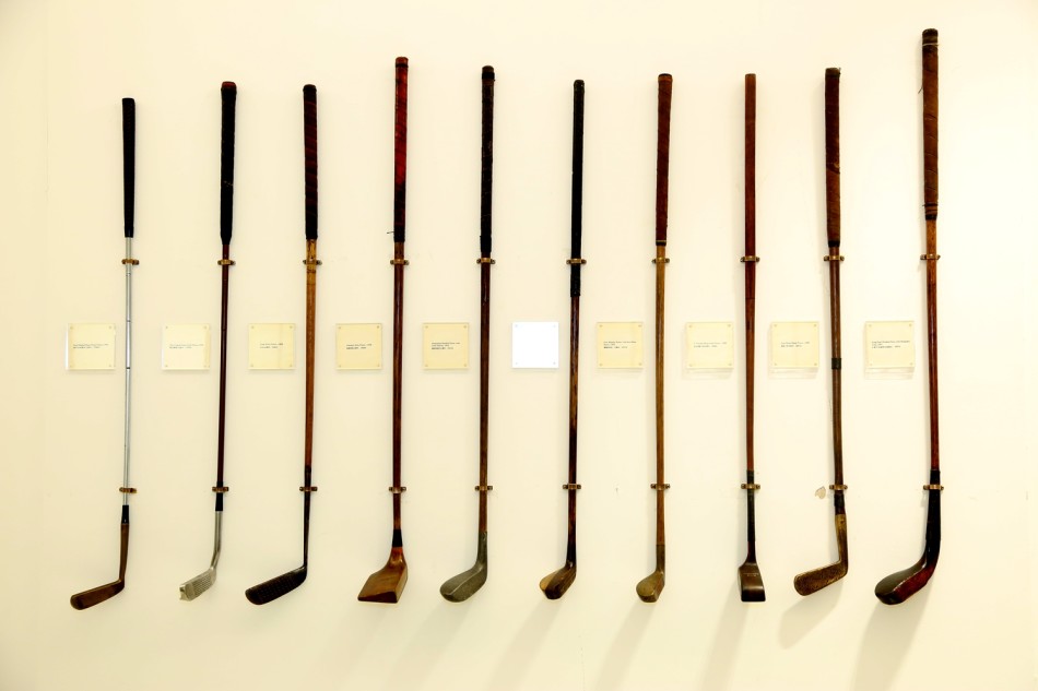 一颗由皮革手工缝制、内部填充羽毛的古老高尔夫球特写，其表面的使用痕迹仿佛烙印着古老的击球瞬间