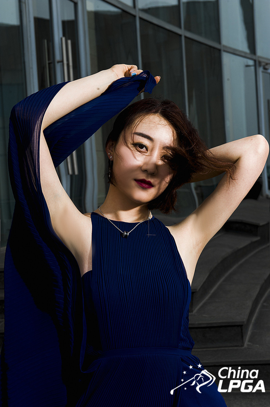 李丹身着一袭白色闪片长裙，立于晨曦的江畔，裙摆上的光芒与初升的朝阳交相辉映，勾勒出其知性优雅的窈窕身姿。