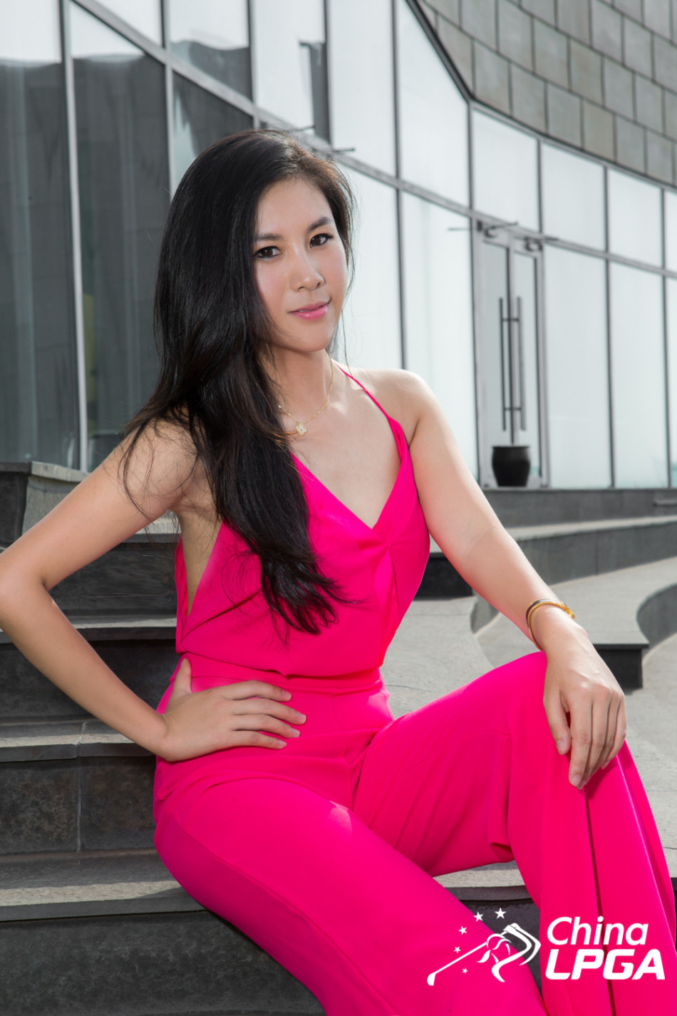 一位模特身穿设计感极强的异域风情长裙，于光影交错的背景前侧身而立，展现出神秘而高贵的气质。