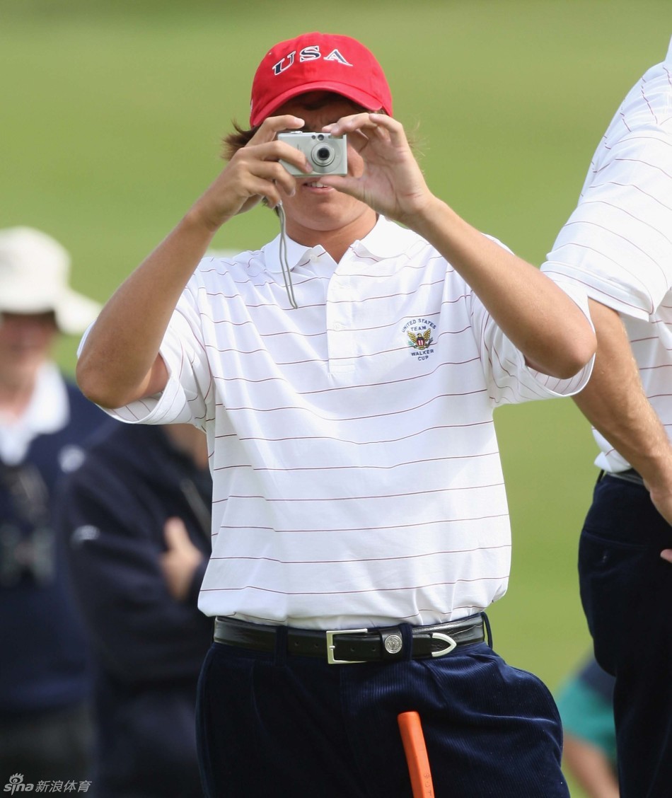 经典橙色！身着经典橙色比赛服自信走向果岭，身后是广阔的球场与天空