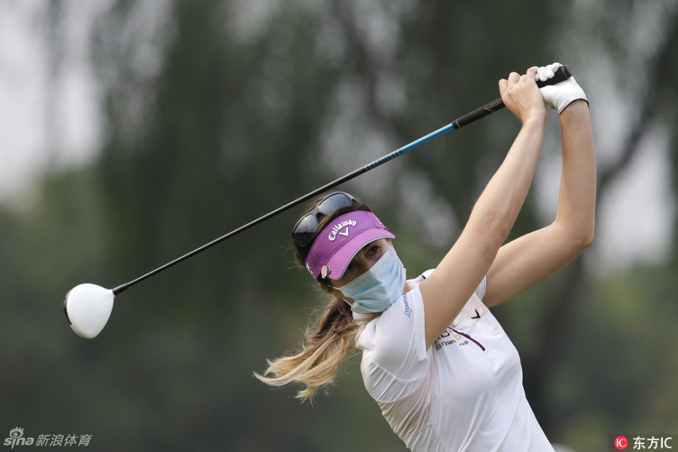 一位球手的身影在浓雾弥漫的球道上显得孤独而坚定，他正专注地瞄准前方完全被白雾吞没的目标。