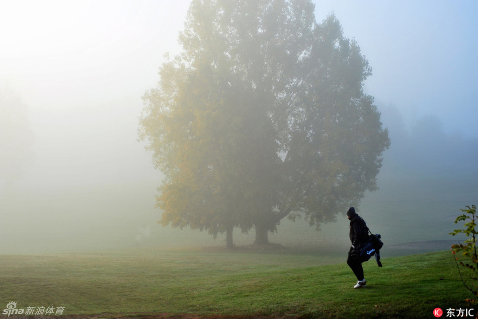 经典的奥古斯塔会所与第18洞果岭在翻涌的雾海中若隐若现，如同海市蜃楼，往日热闹的看台此刻空无一人。