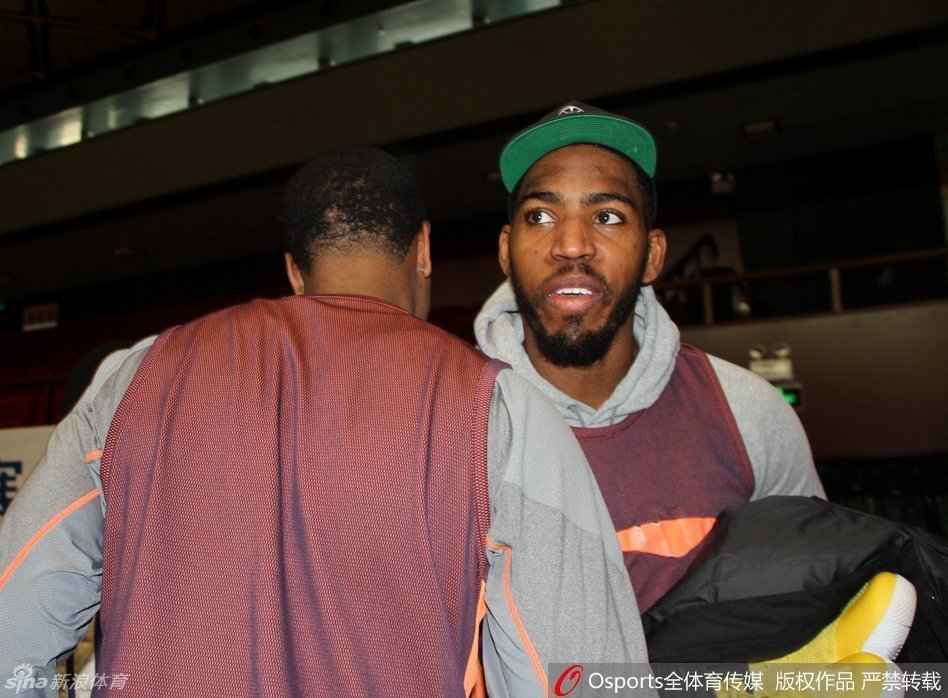 两位CBA外援约什·史密斯与贾森·汤普森在赛前热身时碰面，两人面带笑容，互相致意，仿佛许久未见的老朋友。