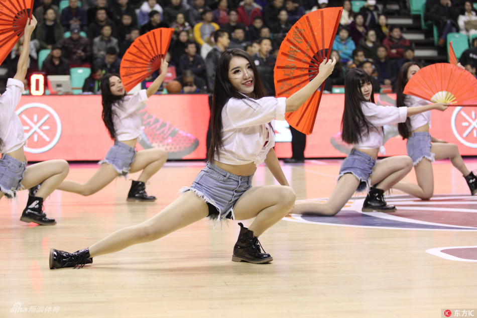 啦啦队队长高举双手，用灿烂如阳的笑容和有力的动作，引领全场的助威节奏