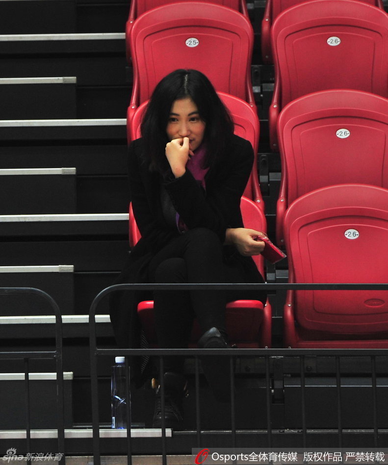 中场休息或比赛间隙，王欣怡整理了一下物品，似乎准备起身离开座位。她的动作优雅从容，脸上依然带着看球时的愉悦神情。