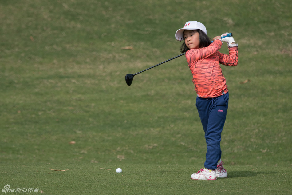 比赛过程中一个充满张力的收杆瞬间，小球员身体姿态保持得极其稳定，目光坚定地望向球飞出的方向。