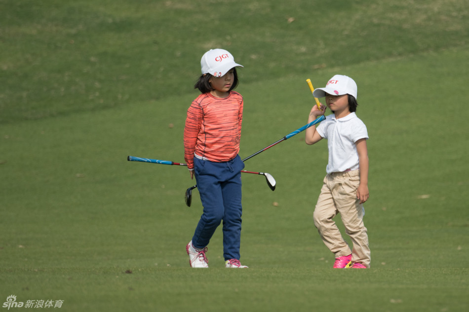 小高尔夫球手以流畅自信的姿势完成一记切杆，球杆在空中划出优雅的弧线，草坪上的小球应声而起。