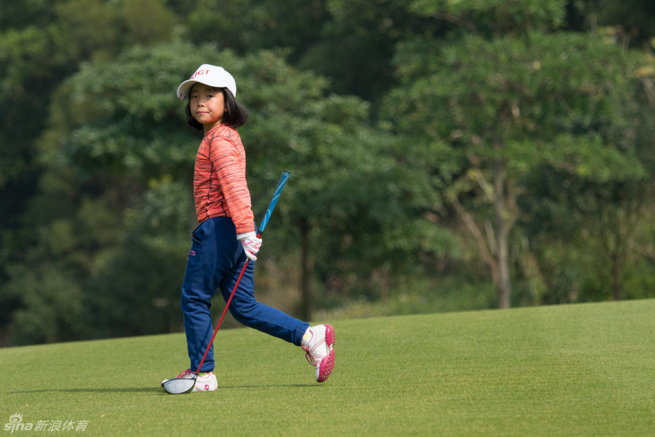 冠军父女的温馨互动瞬间，父亲细心地为刚摘下帽子的女儿整理头发，眼神中充满关爱与骄傲。