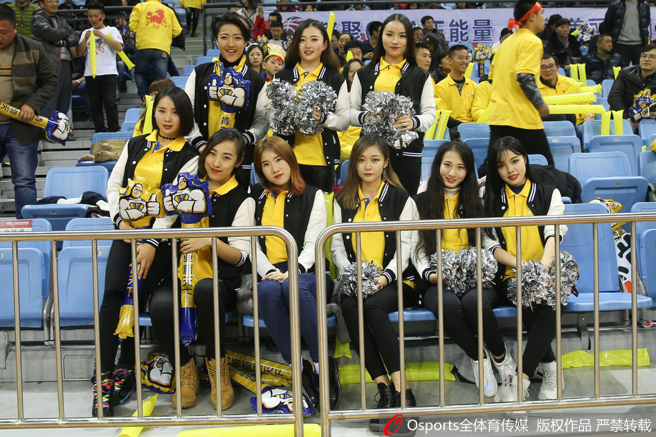 在球队暂停的间隙，几名篮球宝贝在场边排成一排，她们双手叉腰，眼神专注地望向场内，时刻准备着在哨响后再次登场，为观众带来精彩的表演。
