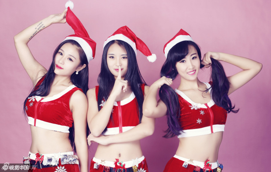 这位篮球宝贝展现出性感出镜的一面，贴身剪裁的圣诞裙装凸显其玲珑曲线，她手举写着心愿的卡牌，脸上洋溢着灿烂的笑容，仿佛在祈愿未来的赛场充满和平与精彩。