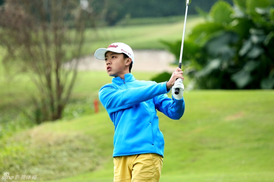 李昊桐在练习场上，身体舒展，正为围聚在身边的小球员们做挥杆动作的核心示范，眼神专注而充满鼓励。