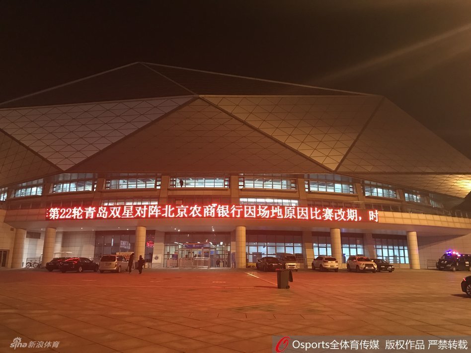 两名穿着制服的保安人员双手背后，面无表情地站在关闭的体育馆入场闸机前，原本应该检票入场的通道空无一人，只有他们守护着这个异常安静的比赛之夜。