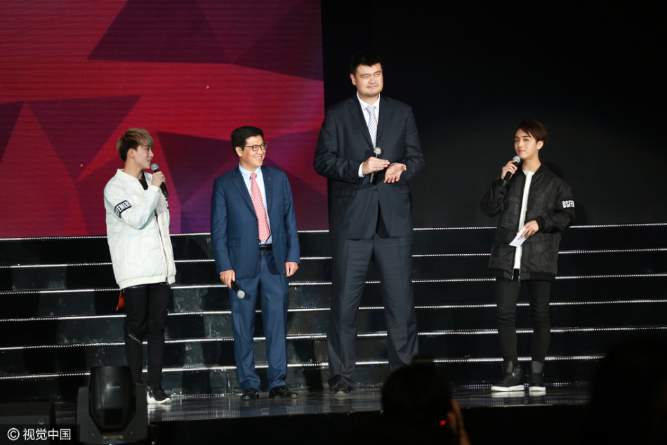 身着一袭深色西装的姚明，在舞台侧幕静静注视着台上的表演，背景的灯光虚化成流光溢彩的光晕，仿佛在沉思着跨界而来的别样体验。