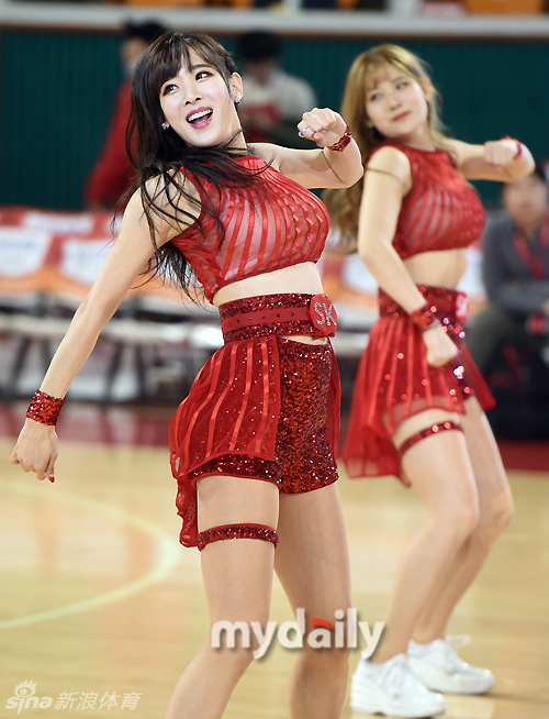 特写镜头下,这位啦啦队员单手叉腰,金色亮片抹胸在灯光下熠熠生辉,她微微侧身回眸,如瀑的长发遮住半边脸颊,眼神中透出自信而迷人的光彩,背景是虚化的看台人海。