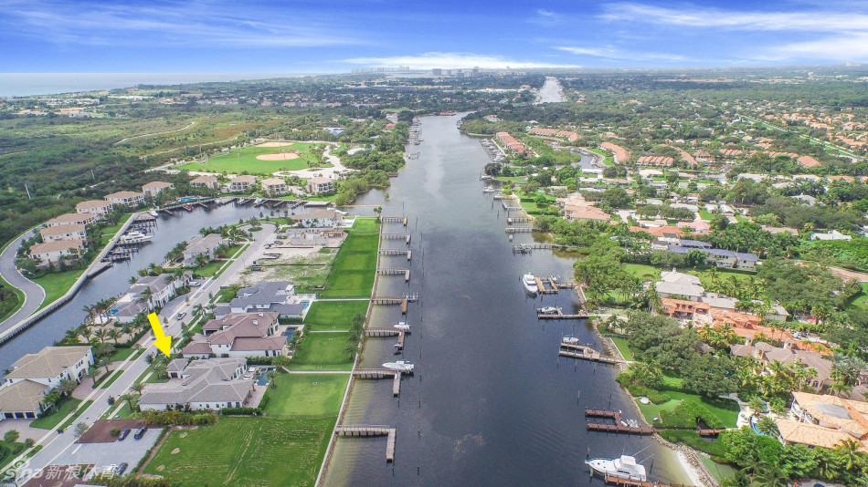 别墅区的空中俯瞰图，展示了精心规划的社区布局、葱郁景观与蜿蜒水道构成的壮丽画卷
