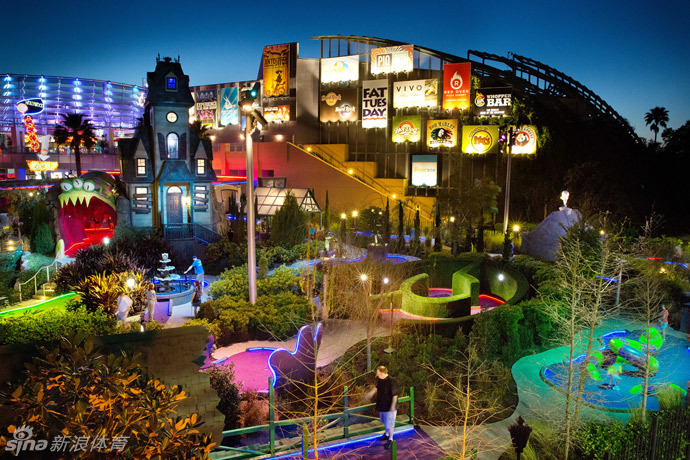 迷你高尔夫球洞的特写,洞口被巧妙地设计成张着大嘴的卡通怪兽形状,等待着将滚入的小球‘吞没’,趣味盎然。