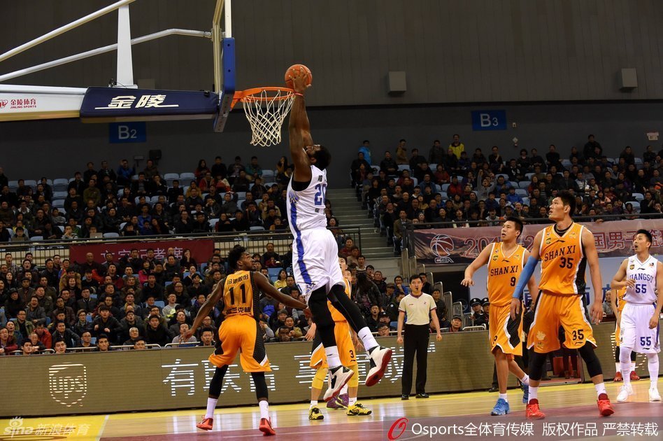 江苏队核心易立在运球突破时，冷静地观察队友跑位，单手将球传向切入篮下的队友，展现出他作为锋线核心的全面视野和团队意识。