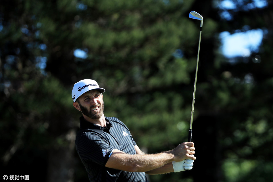 乔丹·斯皮思在球道上与球童沟通，手指明确指向目标方向，展现出非凡的比赛阅读能力和团队协作。