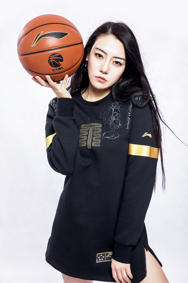 一位气质优雅的女神在赛场通道中被抓拍，她的出现仿佛一道亮光，为激烈的篮球之夜增添了一抹温柔。