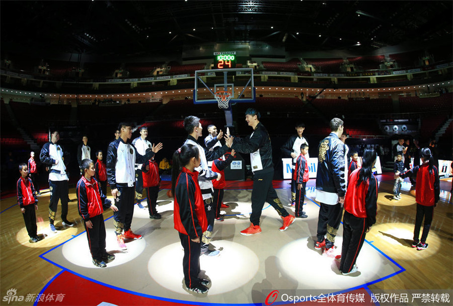 彩排间隙，工作人员递上篮球，球员在灯光下顺手进行投篮热身，篮球在空中旋转，定格了赛前这轻松而专注的一刻。