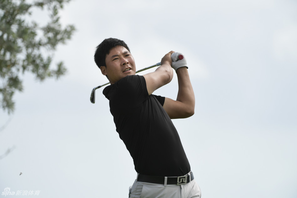 张新军完成一次精准的击球后，优雅地完成收杆动作，双臂高高举起，目光追随小白球飞向球道的中央