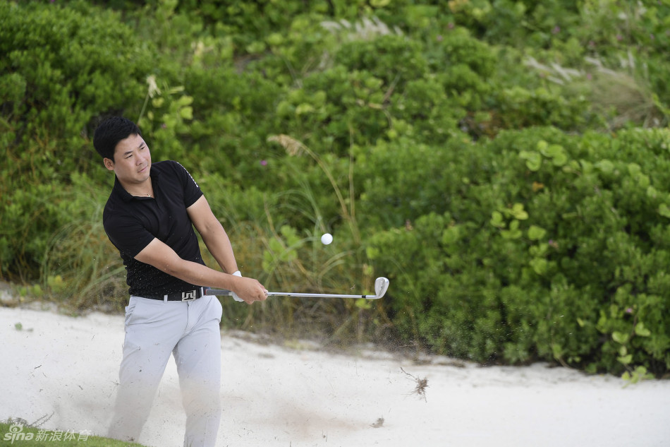 张新军再次面对沙坑挑战，他谨慎地选杆、观察，准备执行一次至关重要的沙坑救球，成败在此一举