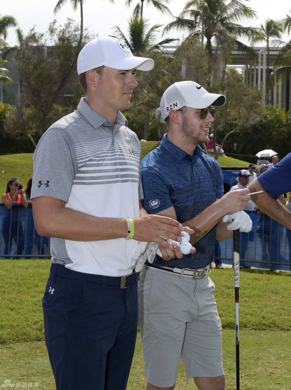 美巡赛主席杰伊·莫纳汉在赛场环境中，侧身与球员凯文·基斯纳进行交流，两人表情认真，似在讨论赛事或球技相关话题。